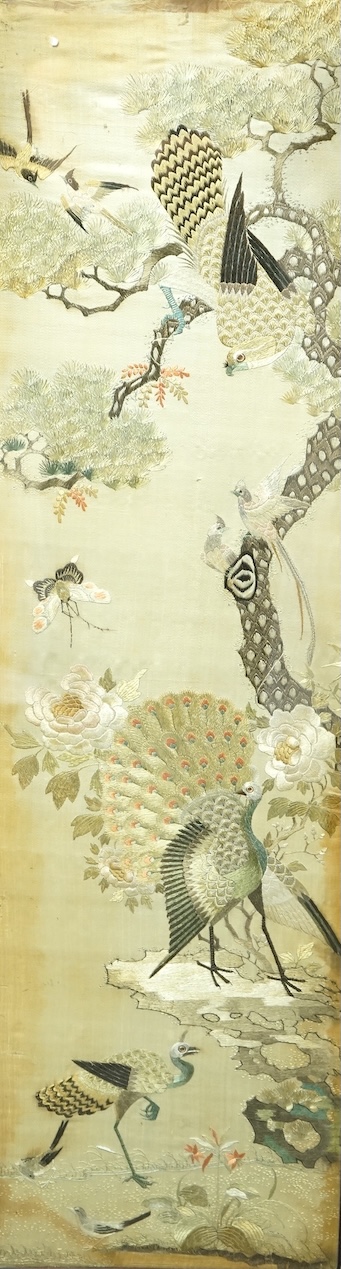 A pair of Chinese embroidered ‘Hundred Bird’ silkwork pictures, c. 1900, in Hongmu and mother-of-pearl inlaid frames, total size 99cm x 32cm. Condition - dark staining and tears to the silk, losses to the mother of pearl